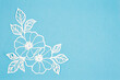 Carve of white paper flower and leaves with copy space on a blue background.