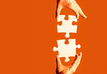 Wall Mural - Hand connecting jigsaw puzzle. Man hands connecting couple puzzle piece. Two hands trying to connect puzzle