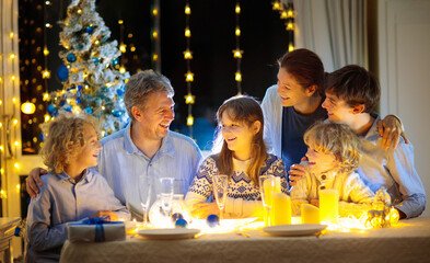 Wall Mural - Christmas dinner. Family with kids at Xmas tree.