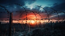 Barbed Wire Fence At Sunset Representing Freedom Breaking Through