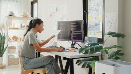 side view of professional young asia girl it development programmer typing on keyboard coding progra