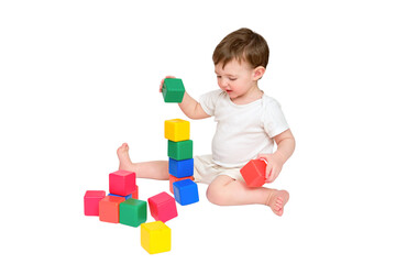 Happy baby play educational toys on studio, isolated on white background. Portrait of a smiling child playing while sitting on the floor, isolated on white background. Kid about two years old