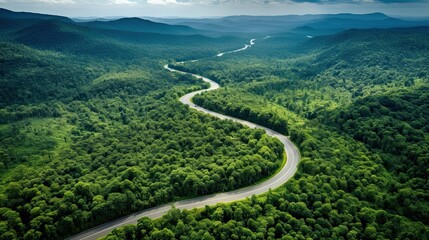 Aerial top view beautiful curve road on green forest in the rain season.