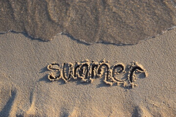 Inscription summer on wet sand. Holiday, rest and enjoyment