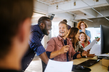 Wall Mural - Diverse group of coworkers working together on a project in the office of a startup company