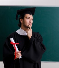 Graduate student in front of green board