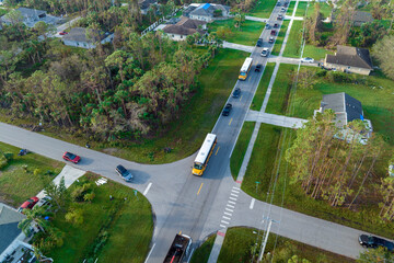 Sticker - Aerial view of american yellow school bus picking up children at sidewalk bus stop for their lessongs in early morning. Public transportation in the USA