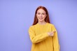 © alfa27 - Young happy red-haired woman over isolated blue background pointing finger to the side, close up portrait. look here come here, advert, advertisement. go there, ad