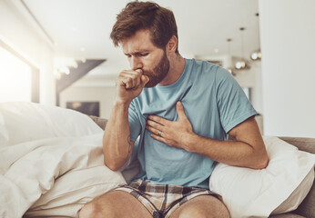 Wall Mural - Sick, coughing and man on a sofa with chest pain, tuberculosis or influenza at home. Asthma, anxiety and male person with breathing trouble in living room with covid, pneumonia or lung virus