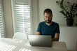 © Cavan - Hispanic man with beard works on laptop