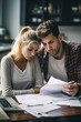 © Jorge Ferreiro - couple analyzing documents and doing calculations between numbers stressed