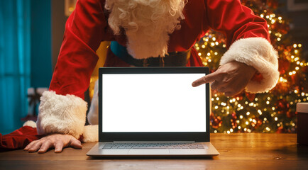 Santa Claus pointing at the laptop screen