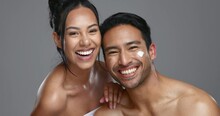 Couple, smile and love for skincare lotion, face and portrait with moisturizer in studio by gray background. Happy people, dermatology and hug in cosmetics, hydration and creme or natural care