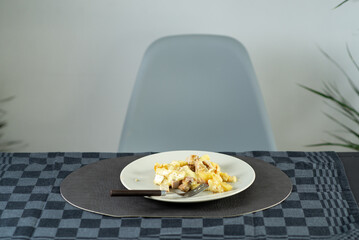 Wall Mural - Fried stewed potatoes with meat and Brie cheese on a plate at the dinner table