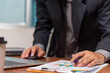 © khunkornStudio - Businessman pointing chart analysis document and paperwork financial plan marketing with laptop on desk office..