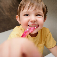 Portrait of a cute little child brushing teeth with a toothbrush. Kid aged two years (two-year-old boy)