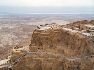 Masada fortress area near Dead Sea in Israel. Ancient fortification in the Southern District of Israel situated on top of isolated rock plateau. Tourists and visitors on the mountain enjoy view