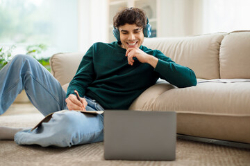 Arabic young student guy watching online lesson via laptop indoor