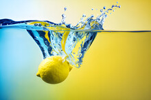 A Lemon Falling Into The Water With A Yellow Background, Lemon Slices Float On The Water, Realistic Water Splashes, Water Background, Lemons.