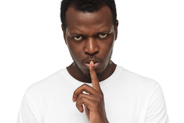 Wall Mural - Close-up shot of angry african american man with shhh gesture, asking for silence or to be quiet