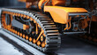 A close up of an orange and black snow plowing vehicle on a platform