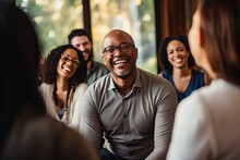 Group Therapy And Support. The Focus Is On A Smiling Middle Aged African American Man In Eyeglasses. A Group Of People Around Support Him.