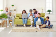 © Studio Romantic - Big family sitting in living room with gadgets, parents, grandparents and two children. Grandpa, mom and grandma looking at smartphones screens, daughter and father working on laptops with son.