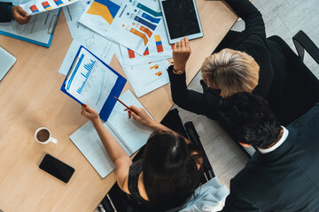 Business people group meeting shot from top view in office . Profession businesswomen, businessmen and office workers working in team conference with project planning document on meeting table . Jivy