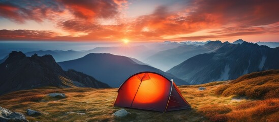 Poster - Vibrant orange tent beneath dramatic sunset in mountainous summer panorama