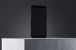 © Who is Danny - Close up of blank smartphone screen on concrete surface and gray wall background. Product presentation and advertisement concept. Mock up, 3D Rendering.