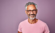 Retrato de un hombre latino maduro, con canas, sonriendo, con apariencia saludable y vitalidad, usando una camisa blanca y gafas, posando en un estudio fotográfico con fondo de color