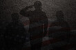 USA army soldier saluting with nation flag on dark textured background. Greeting card for Veterans Day, Memorial Day, Independence Day. America celebration.
