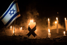 Israel Flag On Burning Dark Background With Candle. Attack On Israel, Mourning For Victims Concept Or Concept Of Crisis Of War And Political Conflict.