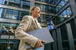 © Yaroslav Astakhov - Female manager going to work while drinking coffee on office building background. High quality photo