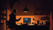 shadow of a man in his room working on a computer at night, yellow lights