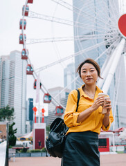 Wall Mural - Modern Asian woman having fun on city fairground