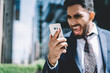 © BullRun - Young businessman looking at phone screen and screaming with anger