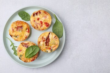 Wall Mural - Freshly baked bacon and egg muffins with cheese on light gray table, top view. Space for text