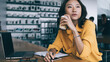 © BullRun - Asian woman drinking coffee and thinking at desk