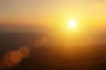 Wall Mural - Natural fog and mountains sunlight background blurring, misty waves warm colors and bright sun light. Christmas background sky sunny color orange light patterns, abstract flare evening on clouds blur.