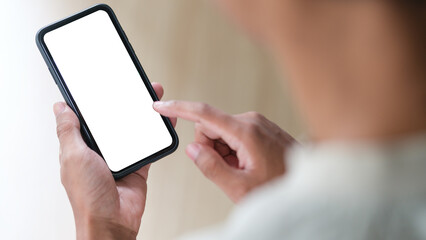 Wall Mural - View over shoulder of man hands holding smart phone. Empty screen for your advertise text.