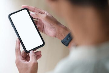 Wall Mural - man hands holding mobile phone while sitting at her workplace. white empty screen for your advertise
