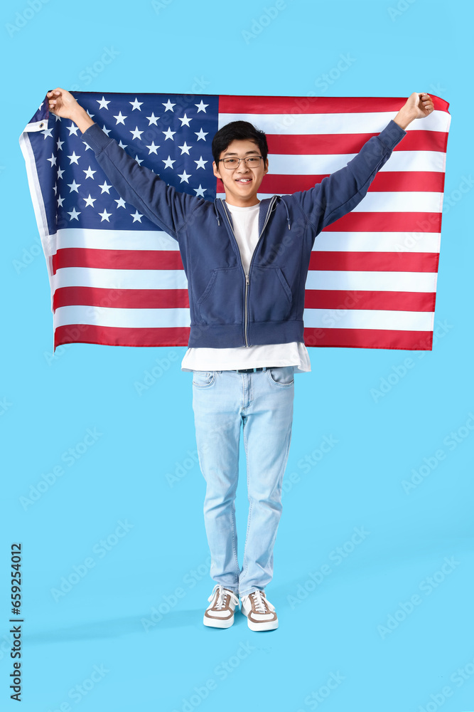 Young Asian man with USA flag on blue background