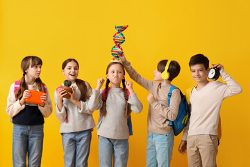 Canvas Print - Little pupils with backpacks on yellow background