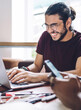 © BullRun - Laughing man typing on laptop meeting with coworkers