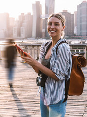 Wall Mural - Half length portrait of cheerful woman tourist with instant camera on neck