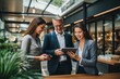 © fledermausstudio - Group of business people using digital tablet