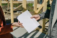 Couple Holding Blueprint At Construction Site