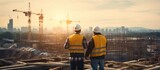 Fototapeta  - Engineer and Architect working on construction site with blueprint at sunset