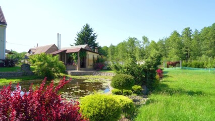 private house and beautiful yard. Landscape with a large gray residential building on a picturesque day with clear blue skies. House in a rural area with majestic nature. High angle footage.